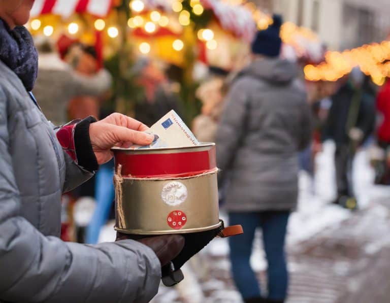 ein spendensammler mit einer spardose aus blech auf einem weihnachtsmarkt der unerkannt ist